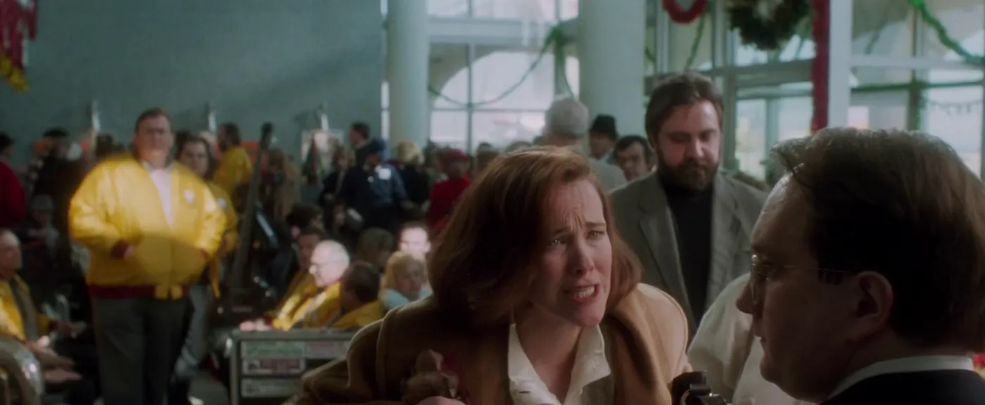Film still from Home Alone of the mom at a ticket counter